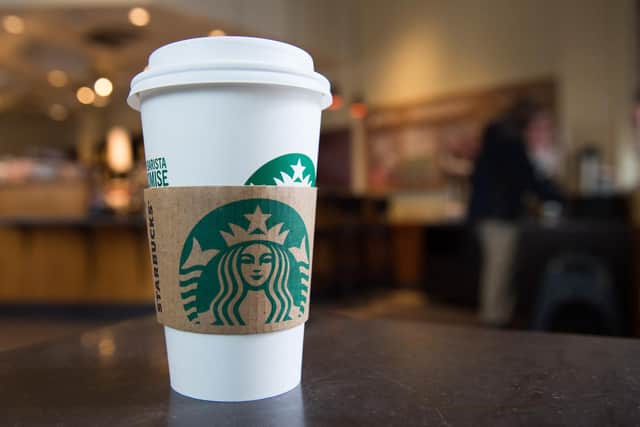 A Starbucks coffee cup is seen inside a Starbucks Coffee shop (Photo by SAUL LOEB/AFP via Getty Images)