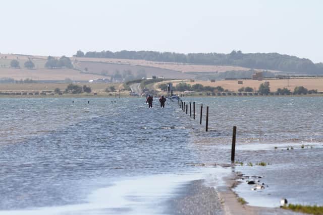 Coastguard officers wade through the water on Holy Island causeway on Wednesday. Picture: Andy Kewin