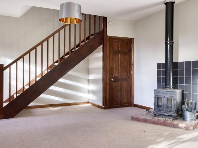 The living room centres around a characterful log-burning stove and also benefits from useful understairs storage.