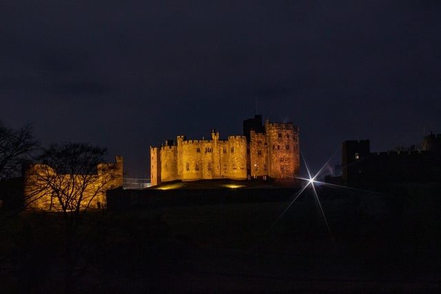 A striking view of Alnwick Castle by night.