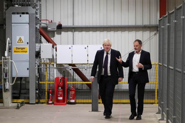 Prime Minister Boris Johnson walks next to Tharsus CEO Brian Palmer during a visit to their headquarters.