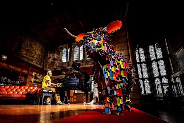 Kev Paxton with the rainbow cow at Bamburgh Castle. Picture: Charlotte Graham Photography.