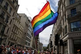 A rainbow flag being held aloft.