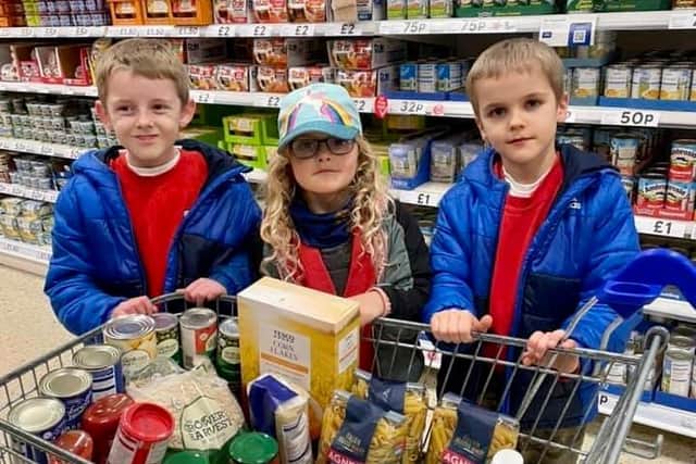 Charlie, Jason and Sofia Bell Taylor, from Belford, with donations for the food bank.