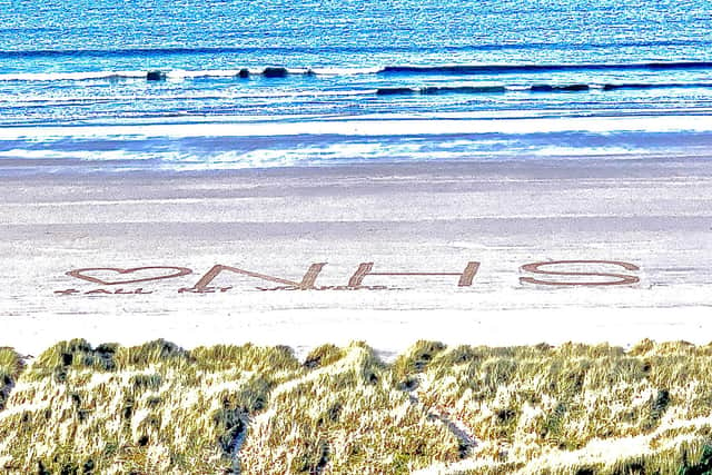 A giant sand art message of support to the NHS on Bamburgh beach.