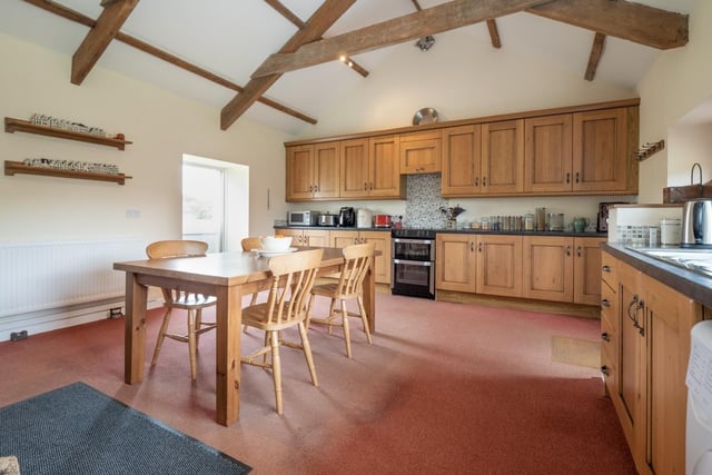 A large kitchen incorporating fitted floor and wall units and a Jotul woodburning stove.