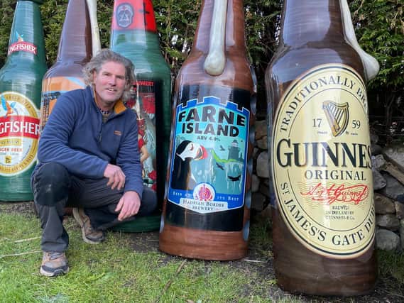 Fin Bowron with some of his fibreglass beer bottles.
