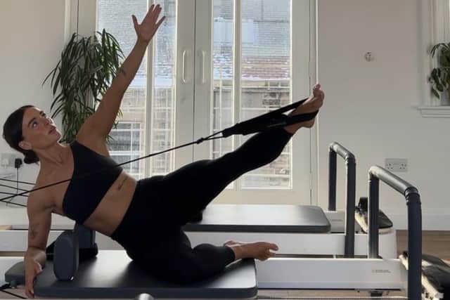 Emily of Bodhi Pilates on one of the Reformer machines.