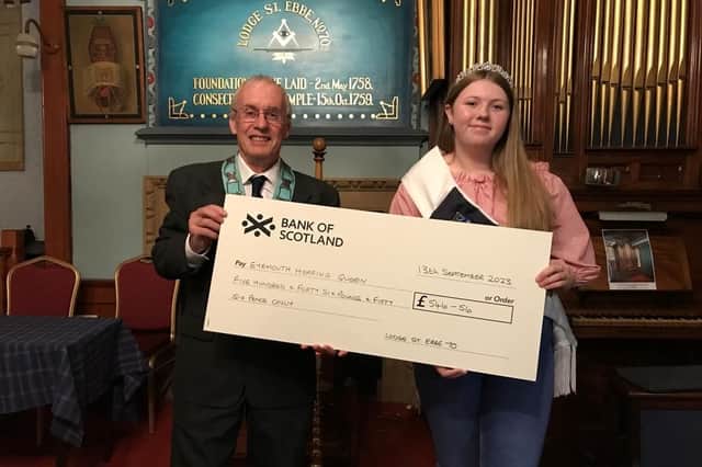 Gordon Thorburn presents the cheque to Eyemouth Herring Queen Sophie Crowe.