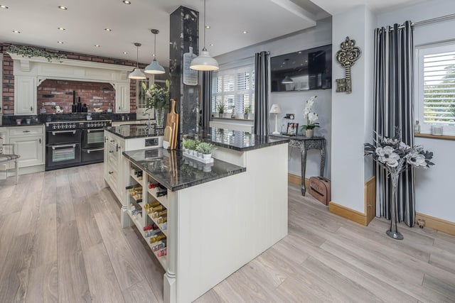 The heart of the home lies in the kitchen, showcasing bespoke wall and base units with granite worktops, a central island and a seven-burner gas range.
