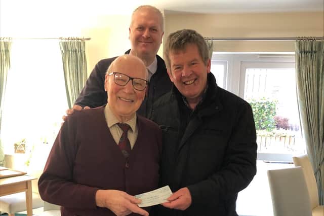 George Young presents Gordon Castle with a cheque.