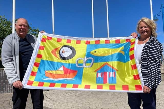 Carole Hardman and her husband Roger with the new Amble flag design.