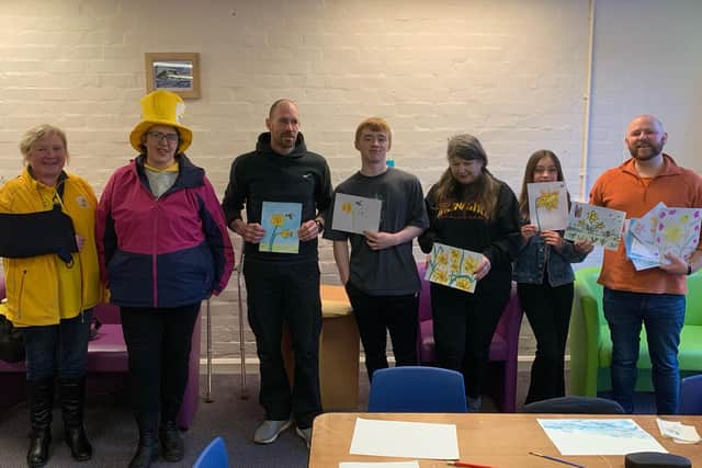 ​Members of the Sunday Art Class run by artist James Alexander Gaffney hand over the artwork to the Marie Curie ladies.