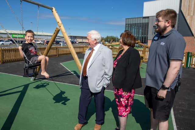 Local boy Joshua tries out one of the swings in the new play park, watched by Coun Jeff Watson, local ward county councillor Isabel Hunter and Keiron Logan, duty manager for Active Northumberland.