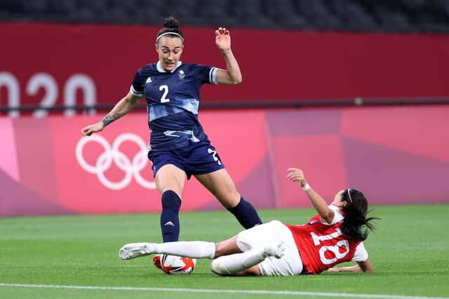 Lucy Bronze, of Team Great Britain, is challenged by Camila Saez, of Team Chile, during the Women's First Round Group E match in the Tokyo 2020 Olympic Games at Sapporo Dome on Wednesday, July 21, 2021, in Sapporo, Japan. Photo by Masashi Hara/Getty Images.