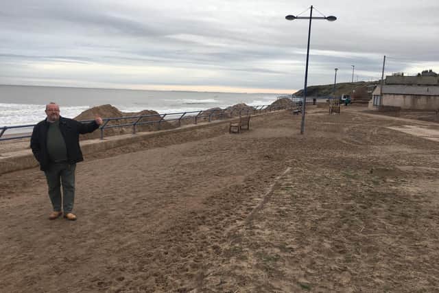 Town Clerk Gareth Davies gives the thumbs up the work to reduce the amount of sand on Spittal promenade by local builder Simon Maden. Picture by Canon Alan Hughes.