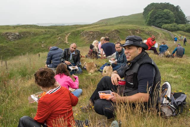 The refugees and asylum seekers stop for a picnic during the walk along Hadrian's Wall.