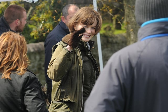 Sporting a dark bob in her role as Patti Lomax, Nilcole Kidman waves to fans.