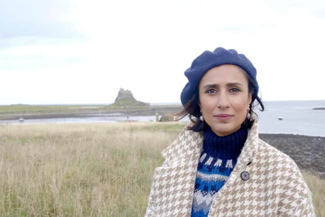 Anita Rani on Holy Island with Lindisfarne Castle in the background.