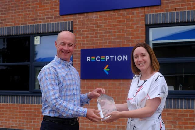 TruStack's commercial director, Phil Cambers, holds the award with Emma Batey, channel account manager at Arctic Wolf.