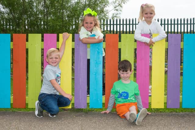 St Bede's RC Primary students next to their newly painted fence at Nursery.