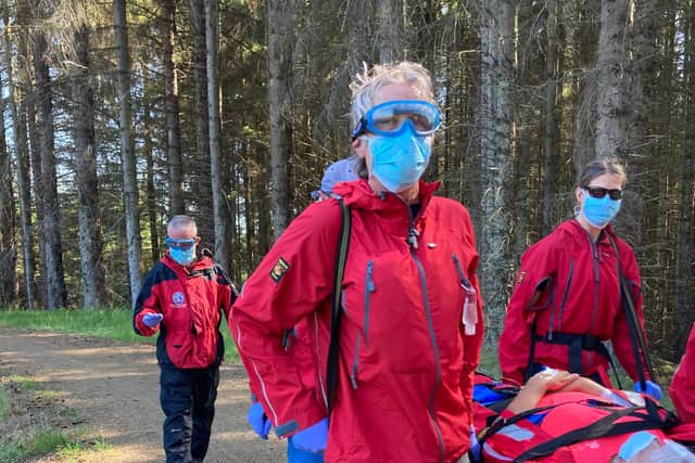 Mountain rescue teams assist a woman injured after falling off her bike at Kielder.
