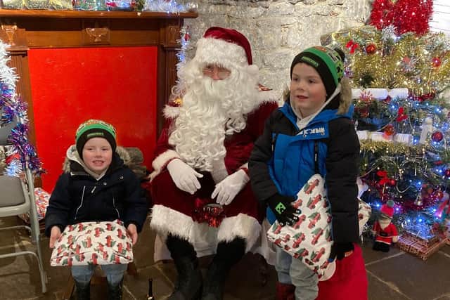 Brothers Arron (five) and Jake (three) pictured with Santa at Cresswell Pele Tower.
