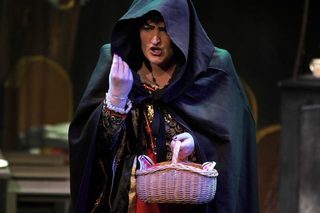 Evil Queen Avarice (Diane Renner) planning to poison Snow White with an apple in the Spittal Variety Group pantomime.