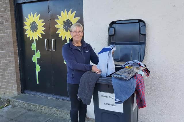 Northern View director Isabel Litster standing next to the Warm Clothes Exchange collection bin at the sunflower door entrance.