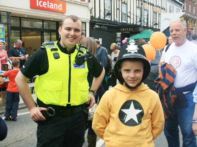 A young visitor from Chernobyl wears a policeman's helmet.