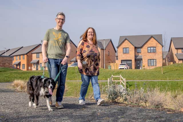 Rob Dooley and Su Fitton walking dog Dexter outside their new home at Woodgreen in Blyth.