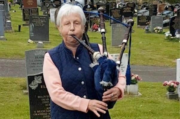 Bagpiper Iris Hannah plays a tribute to the Railway Man, former army officer Eric Lomax, at his grave, in Berwick. Picture from video by Andrew Blair