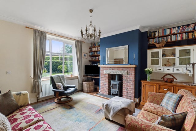 The charming and cosy lounge includes a brick and stone fireplace with a wood burner.