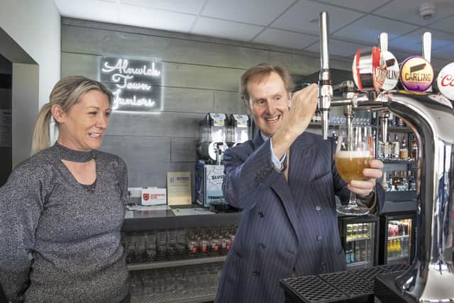 The Duke of Northumberland, watched by club chairman Louise Jones, pours a pint in the new clubhouse. Picture: Alnwick Town Council