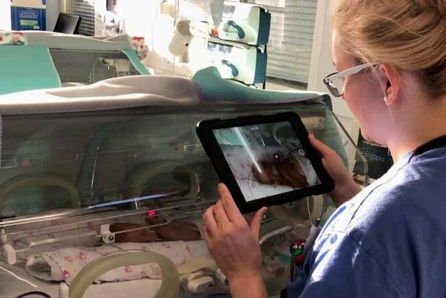 A nurse uses the vCreate software to share updates on a poorly baby with family.