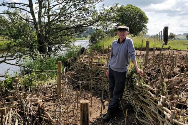 Alan Winlow with his willow barriers on the banks of the River Coquet. Picture by Katie Scott