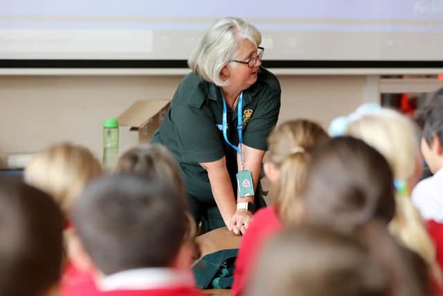 A member of staff from North East Ambulance Service teaches vital CPR training to youngsters.