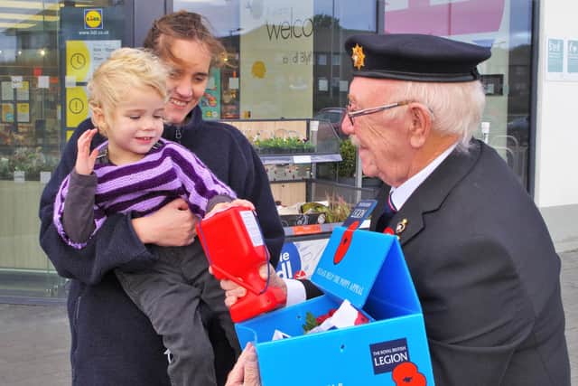 Joannie Robertson (3) with mum Nichola buys a poppy from Blyth British Legion member Rick Young.