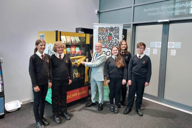 Mayor Geoff Watson opens the new book vending machine.