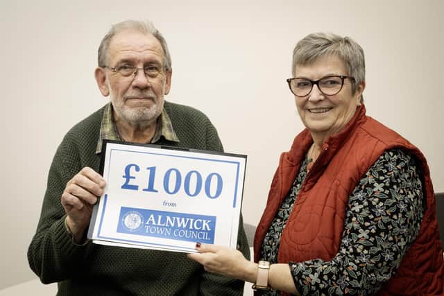 Mike Alexander is presented with £1,000 from Cllr Lynda Wearn.