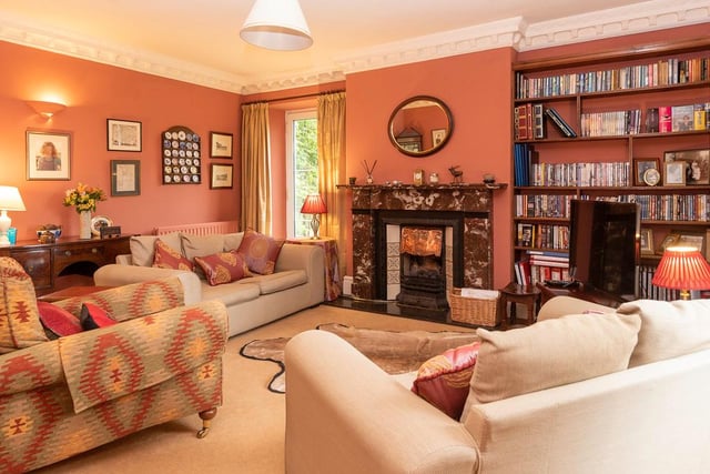A large formal reception room is fitted with a beautiful fireplace with wood burning stove.