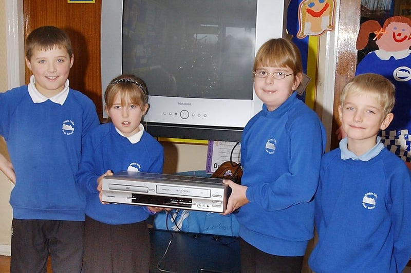 Pupils from Amble Links County First School receive a TV and DVD from the money raised from the PTA in December 2003.