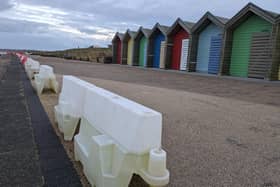 Plastic barriers are in place along the promenade after sand was washed away by winter storms. (Photo by National World)