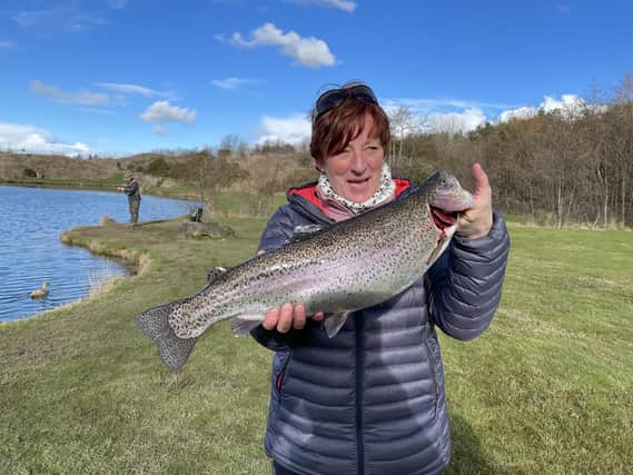 Helen with the rainbow trout she caught. Picture: Bob Smith