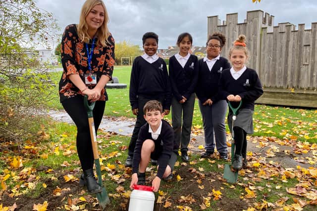 Burial of the time capsule is carried out by pupils and a member of staff at Stobhillgate First School.