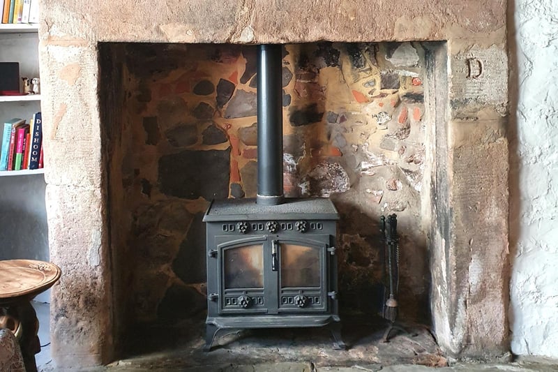 The multi-fuel stove is surrounded by a fireplace made of sandstone, which is believed to have been recovered from the ruins of Berwick Castle.