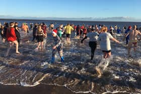 Spittal Boxing Day Dip 2022 participants head into the North Sea. Picture by Alan Hughes.