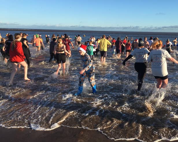 Spittal Boxing Day Dip 2022 participants head into the North Sea. Picture by Alan Hughes.