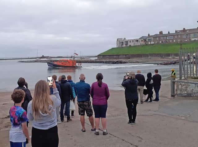 Onlookers watch as the lifeboat launches