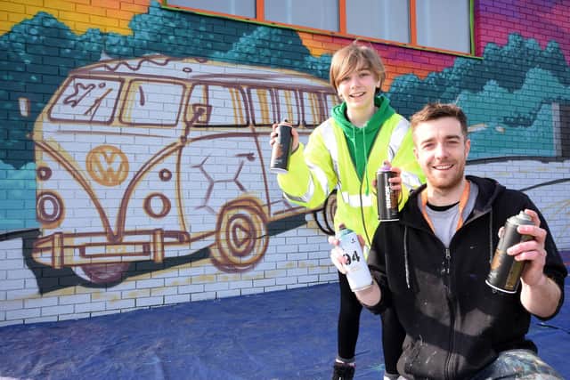 Emily Clapham and artist Mark Shields with Emily’s mural at the Tyne Tunnels.